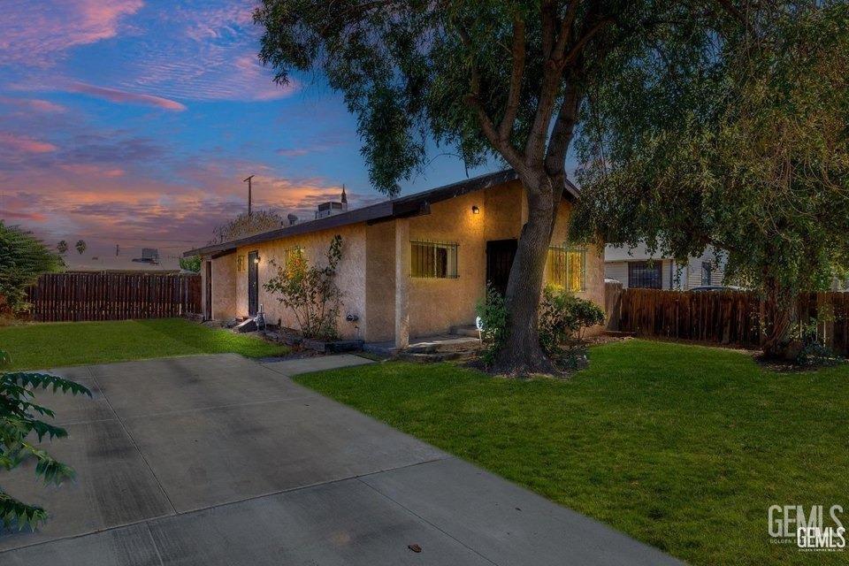 726 Belmont St, Delano, CA 93215 - bungalow-style home with a front yard, fence, and stucco siding