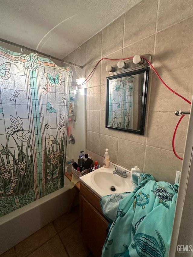 bathroom with tile patterned flooring, tile walls, shower / tub combo, a textured ceiling, and vanity