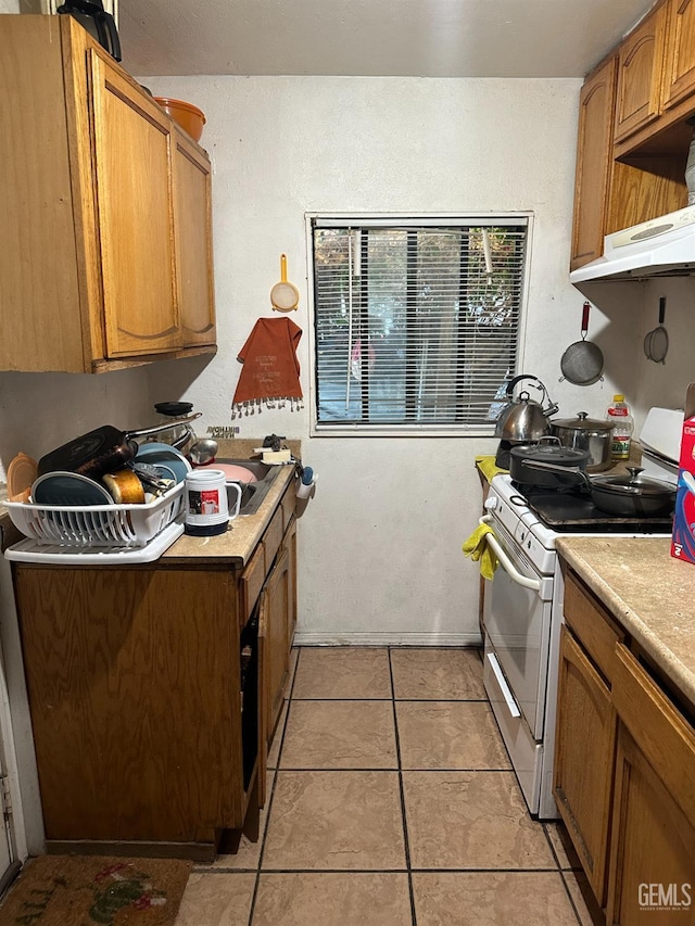 kitchen featuring light tile patterned floors and white gas range