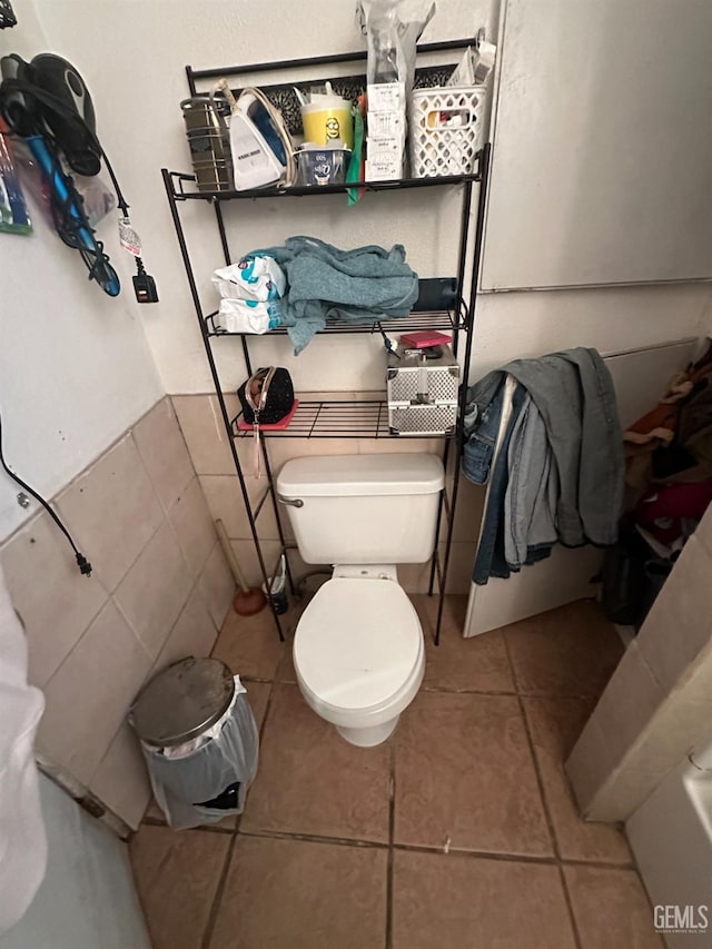 bathroom with tile walls, toilet, and tile patterned flooring