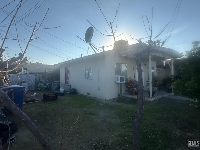 view of side of home featuring cooling unit and a yard