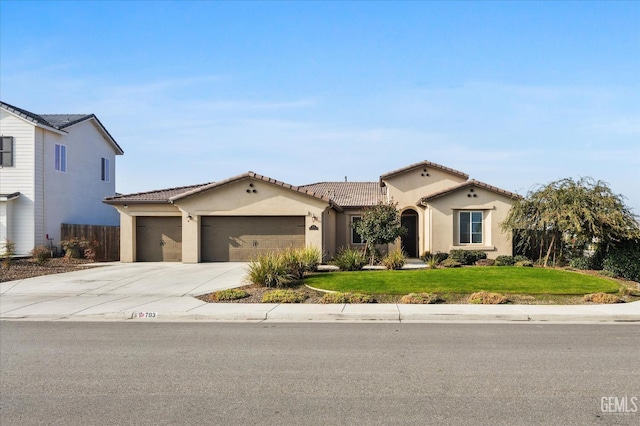 mediterranean / spanish home featuring a garage and a front yard