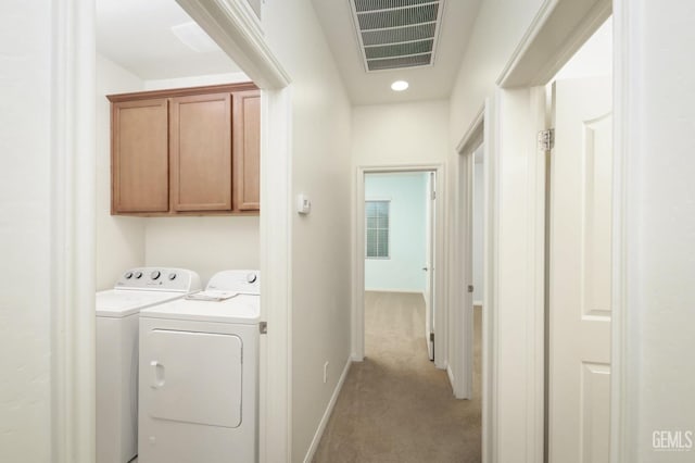 laundry area with cabinets, light carpet, and washing machine and dryer