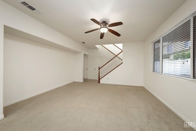 basement with light colored carpet and ceiling fan