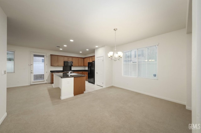 kitchen with light carpet, black appliances, decorative light fixtures, an inviting chandelier, and a kitchen island