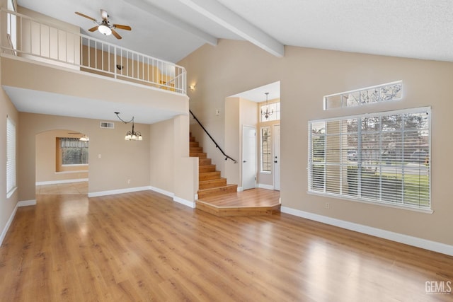 unfurnished living room with beamed ceiling, ceiling fan with notable chandelier, hardwood / wood-style floors, and high vaulted ceiling