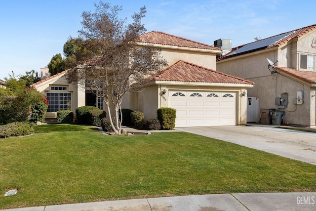 mediterranean / spanish house with a garage and a front lawn