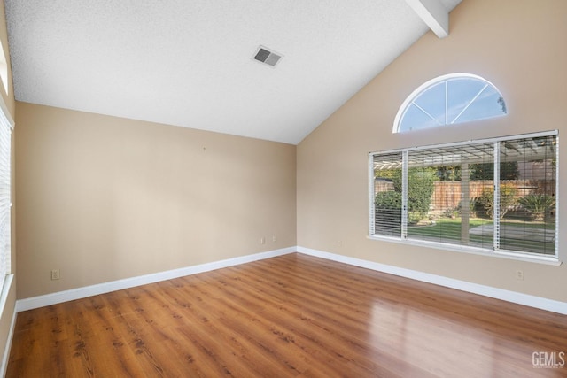 unfurnished room with wood-type flooring, high vaulted ceiling, and beamed ceiling