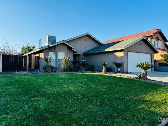 ranch-style home featuring cooling unit, a garage, and a front yard