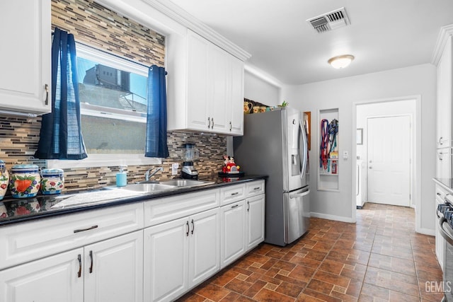 kitchen with sink, backsplash, white cabinets, and stainless steel appliances