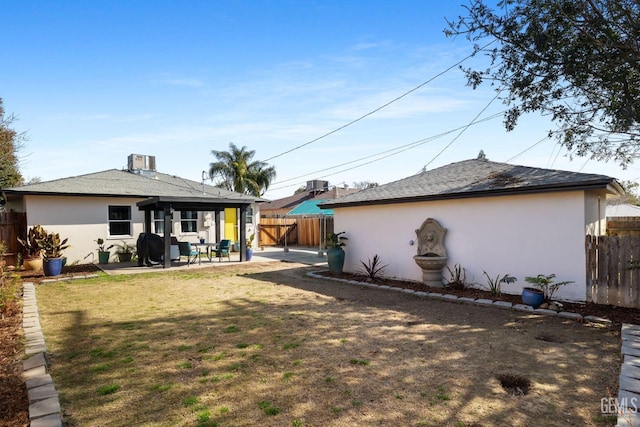 rear view of house with a patio and a lawn