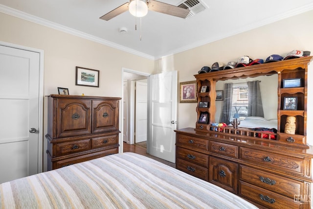 bedroom with ceiling fan, ornamental molding, and wood-type flooring