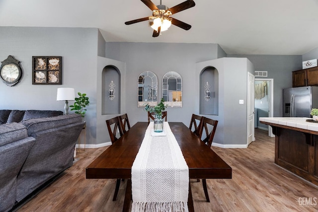 dining room featuring light wood-type flooring, visible vents, and baseboards