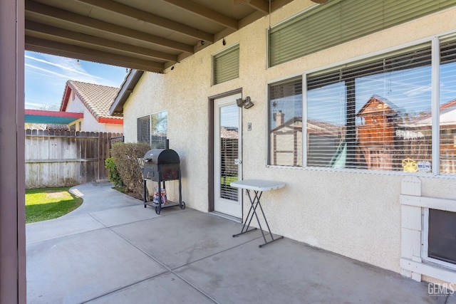 view of patio with a grill and fence