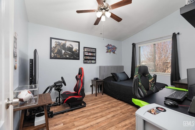 bedroom featuring a ceiling fan, vaulted ceiling, and light wood-style flooring