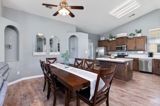 dining space featuring light wood-style floors, ceiling fan, visible vents, and baseboards