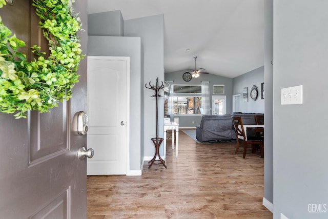 entrance foyer with vaulted ceiling, light wood-type flooring, a ceiling fan, and baseboards