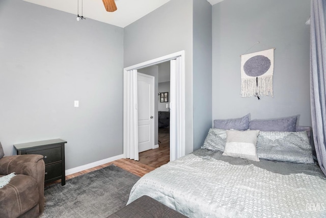 bedroom with wood finished floors, a ceiling fan, and baseboards