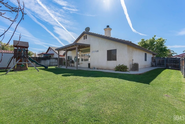 back of property featuring central AC unit, a fenced backyard, a patio area, a playground, and stucco siding