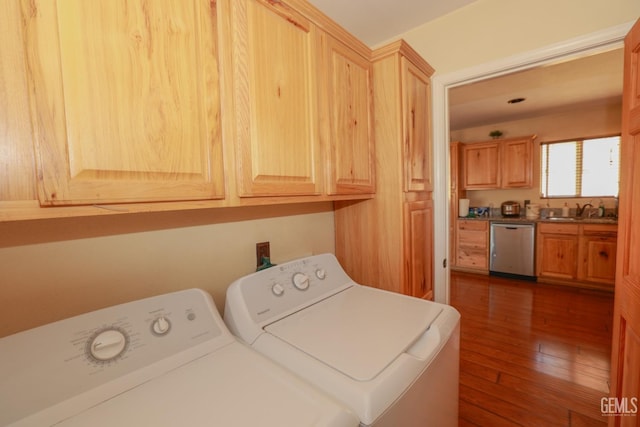 clothes washing area featuring separate washer and dryer, sink, cabinets, and dark hardwood / wood-style flooring