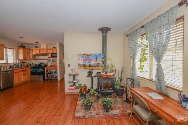 interior space with a wood stove, plenty of natural light, and light wood-type flooring