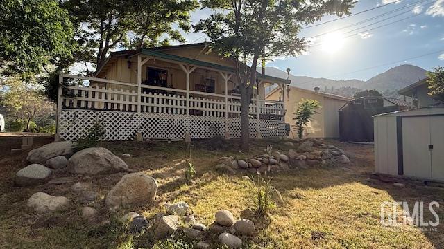 rear view of property with a storage unit, an outdoor structure, and a porch