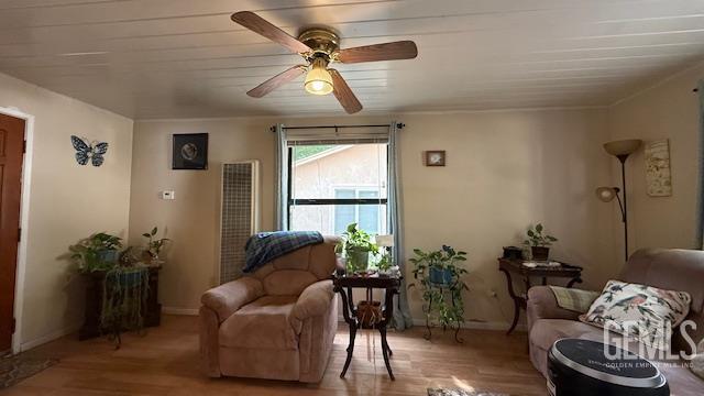 living room featuring wood finished floors, ceiling fan, a heating unit, and baseboards