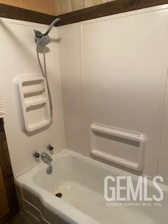 bathroom with washtub / shower combination