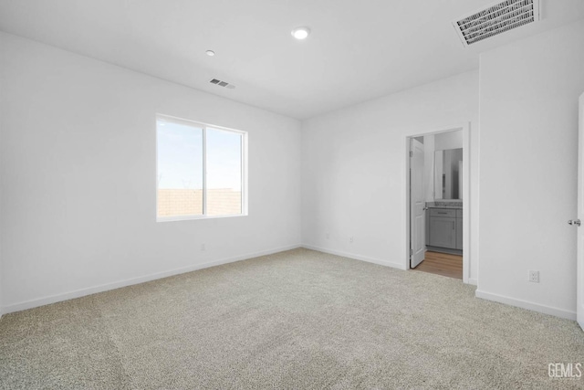 unfurnished room featuring light colored carpet