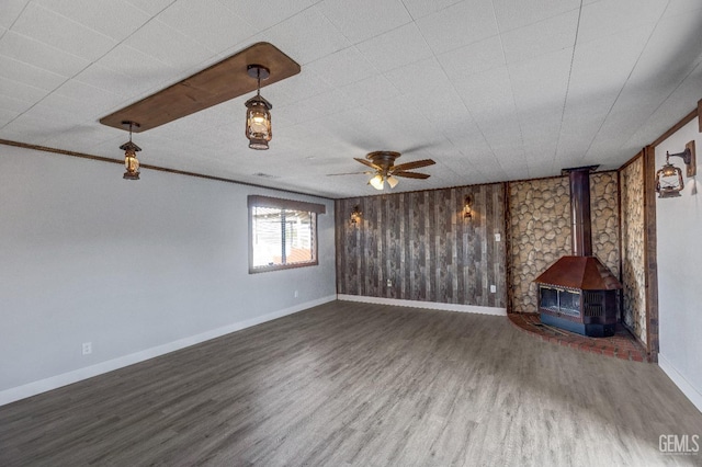 113 Lucard St, Taft, CA 93268 - unfurnished living room featuring a wood stove, wood finished floors, baseboards, ceiling fan, and ornamental molding