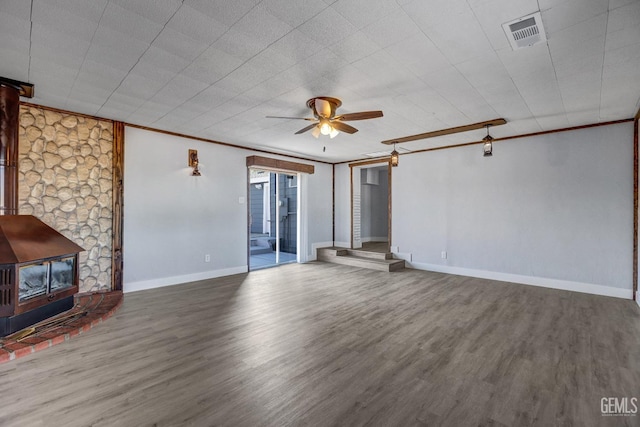 113 Lucard St, Taft, CA 93268 - unfurnished living room featuring a wood stove, wood finished floors, ceiling fan, ornamental molding, and baseboards