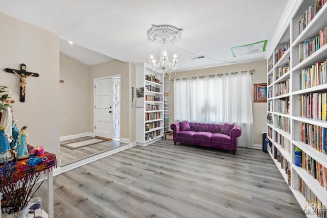 3105 Whisper Oak Way, Bakersfield, CA 93311 - sitting room featuring a chandelier, wood finished floors, bookshelves, baseboards, and vaulted ceiling