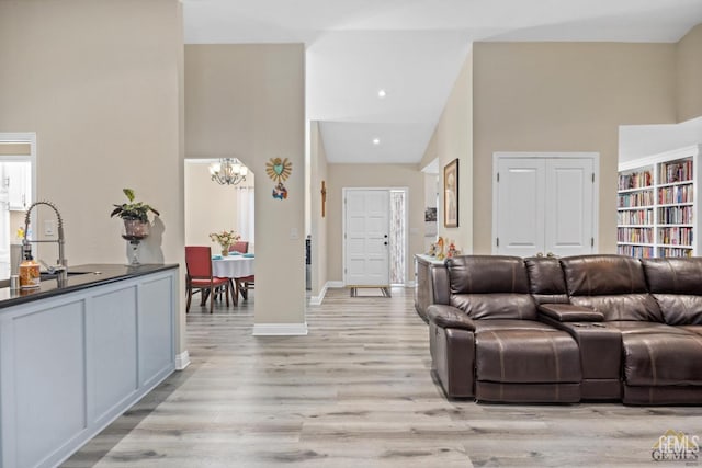 3105 Whisper Oak Way, Bakersfield, CA 93311 - living area with a chandelier, light wood-style floors, baseboards, and a high ceiling