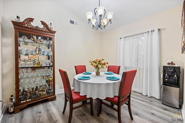 3105 Whisper Oak Way, Bakersfield, CA 93311 - dining room featuring a chandelier, vaulted ceiling, light wood-style floors, and baseboards