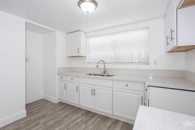 kitchen featuring white cabinets, light hardwood / wood-style floors, and sink