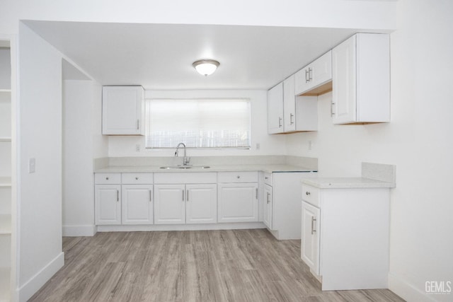 kitchen featuring light hardwood / wood-style floors, white cabinetry, and sink