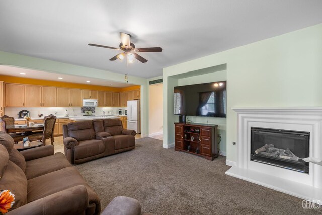 10114 Oporto Way, Bakersfield, CA 93306 - carpeted living area with ceiling fan, a glass covered fireplace, and baseboards