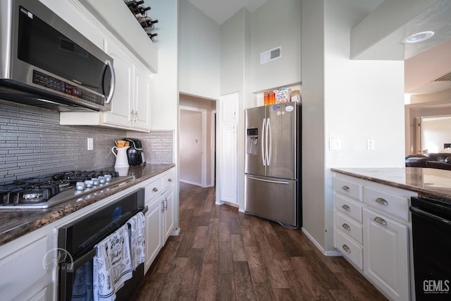 kitchen with black appliances, white cabinetry, dark hardwood / wood-style floors, and dark stone countertops