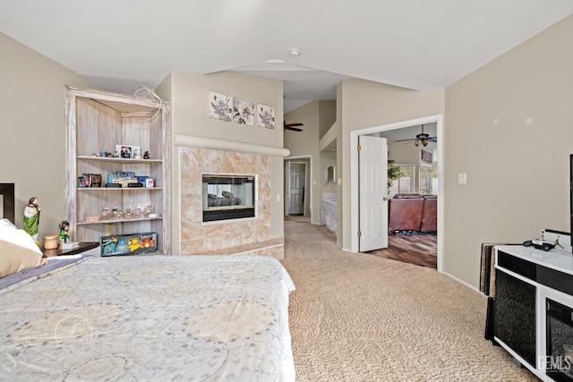 bedroom featuring vaulted ceiling, carpet flooring, and a fireplace