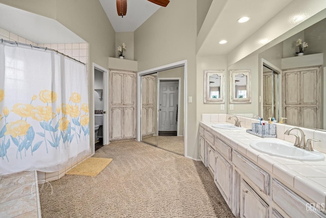 bathroom featuring vaulted ceiling, ceiling fan, and vanity