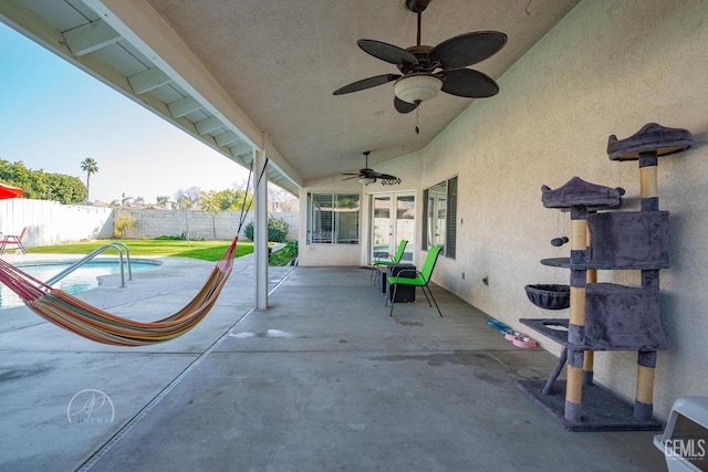 view of patio featuring a fenced in pool and ceiling fan