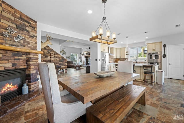 dining space featuring sink, a wealth of natural light, and a fireplace