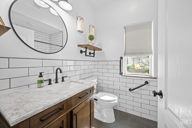 bathroom featuring vanity, toilet, tile patterned floors, and tile walls