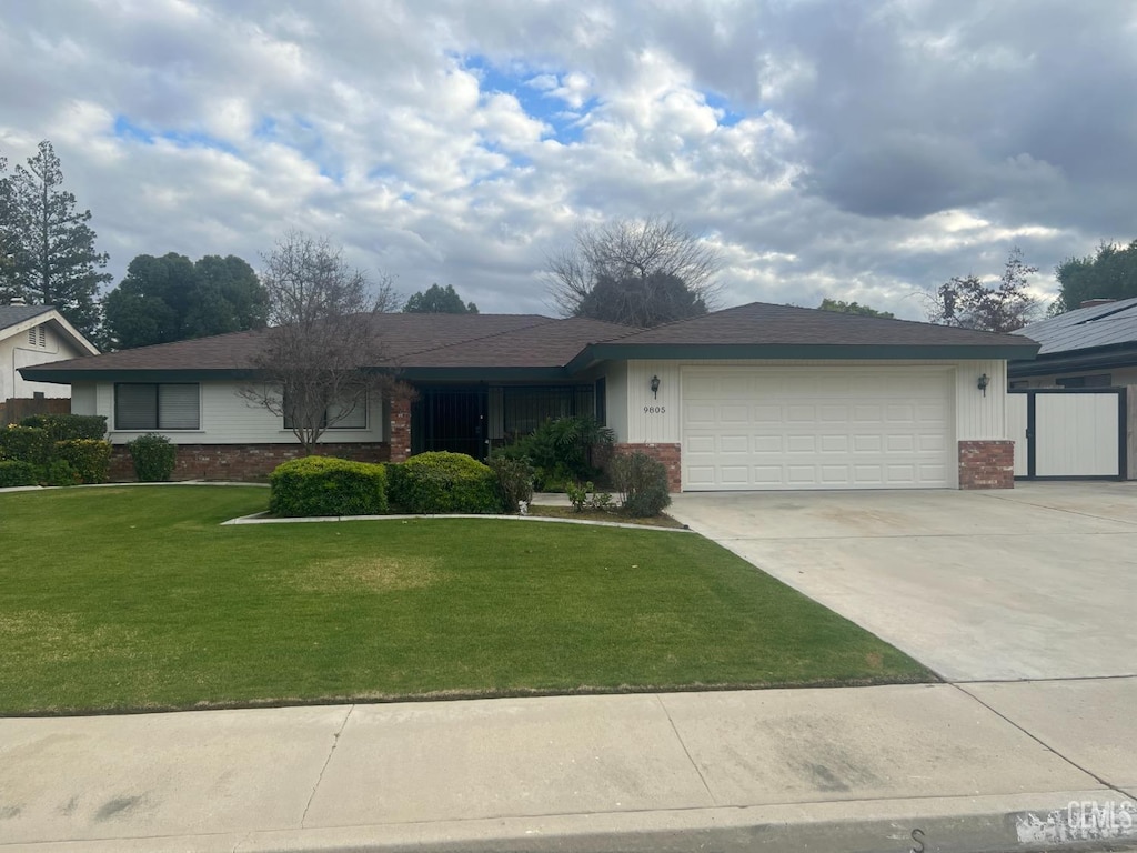 ranch-style house with a garage and a front lawn