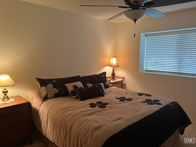 bedroom with ceiling fan and a textured ceiling