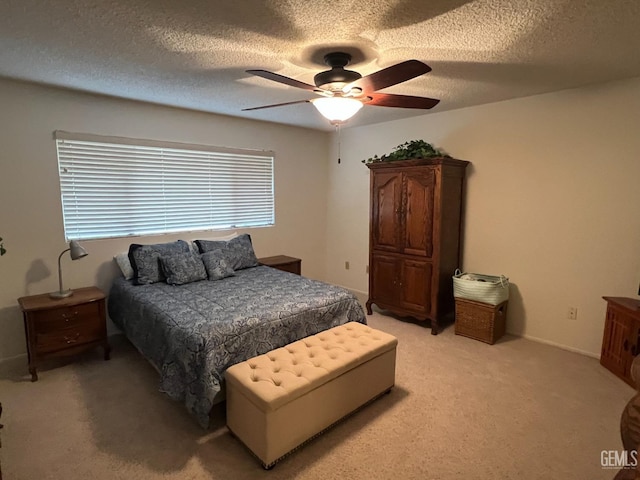 carpeted bedroom with ceiling fan and a textured ceiling