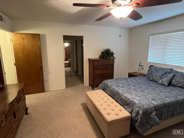 carpeted bedroom with ceiling fan and a textured ceiling