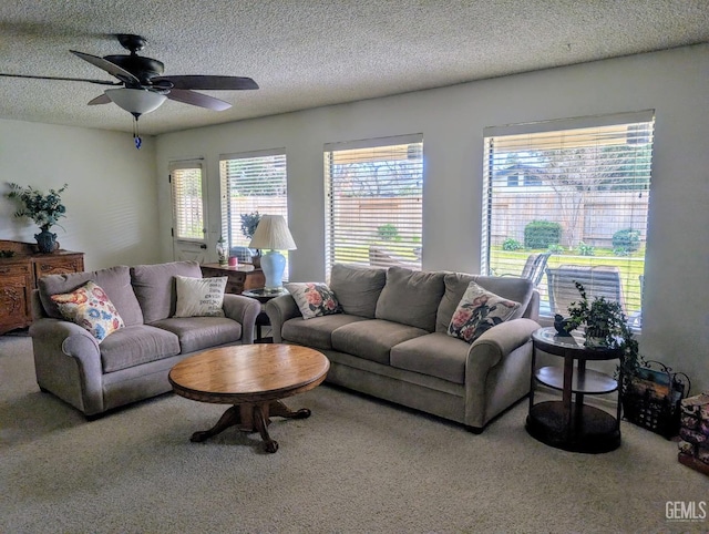 carpeted living room with ceiling fan and a textured ceiling