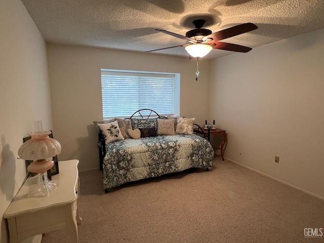 carpeted bedroom with ceiling fan and a textured ceiling