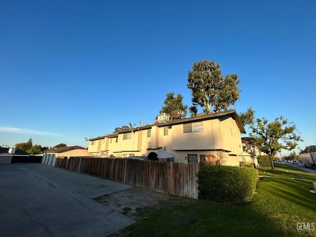 view of side of property featuring fence and stucco siding